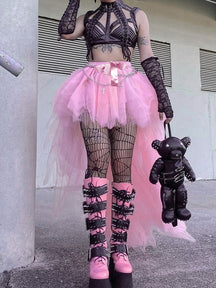 Pink high-low mesh tutu skirt worn with a black halter top, patterned stockings and tall black boots, with a large ribbon bow at the waist.