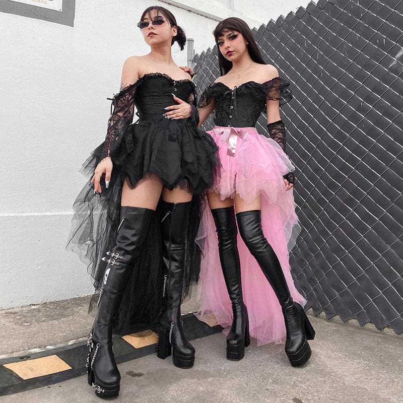 Wider paired outfit view of the black and pink tutu skirts beside a fence, showing both gathered waistlines and pointed mesh hems.