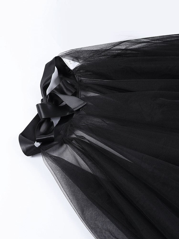 Close-up of the black skirt’s wide ribbon bow and gathered waistband above the first mesh layer.