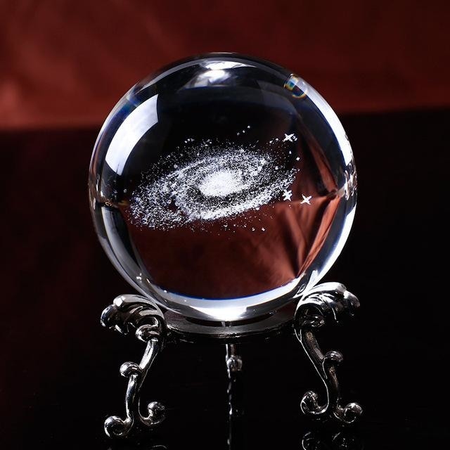 Additional copy of the silver-tone stand view, showing the white galaxy spiral suspended-looking within the clear ball.