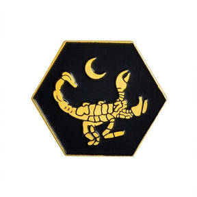Gold-tone scorpion pin with a curved segmented tail and dark enamel details, an additional design shown in the gallery.