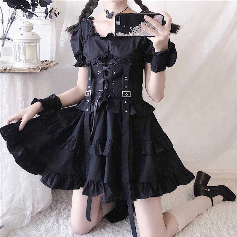 Black gothic dress shown in a kneeling mirror view, with the frilled skirt lifted slightly to reveal its layered shape.