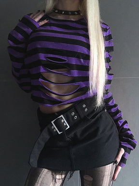 Purple and black striped crop sweater styled with a black skirt, showing the large horizontal front cutouts and long sleeves.