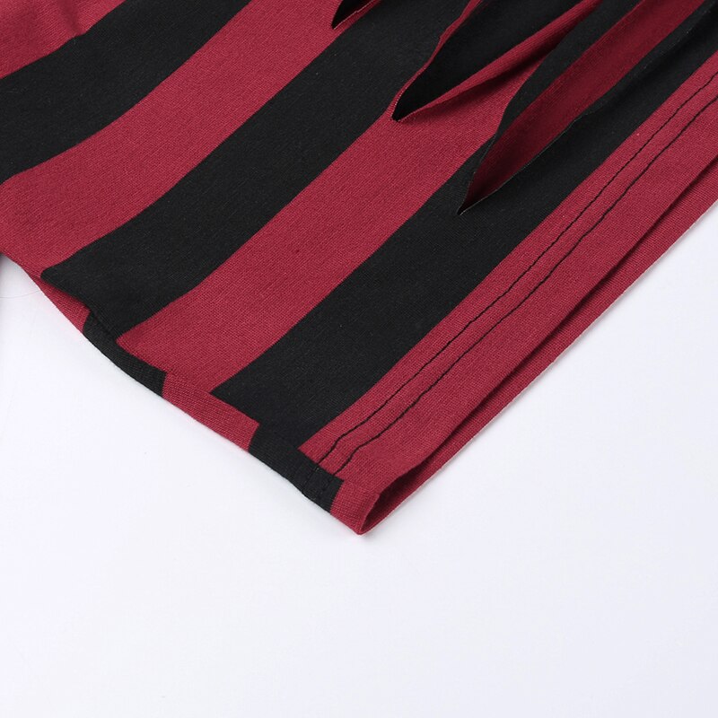 Stitched lower edge of the red and black striped sweater shown closely against a pale background.