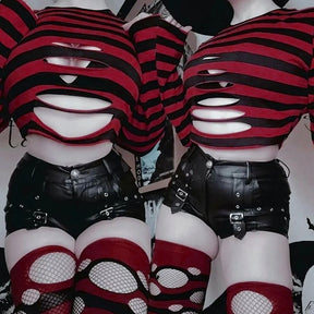 Two people wearing red and black slashed crop sweaters with black shorts and red fishnet stockings, posed side by side.