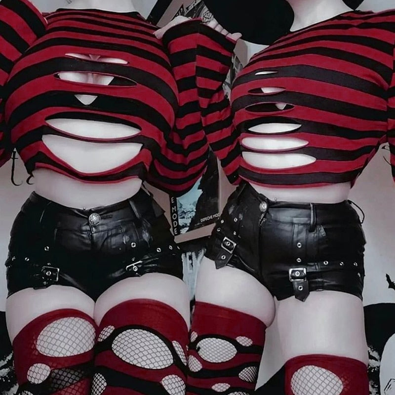 Two people wearing red and black slashed crop sweaters with black shorts and red fishnet stockings, posed side by side.