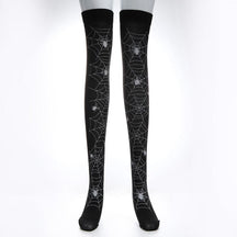 Black thigh-high stockings with pale spiderweb lines extending across the legs, isolated against white.
