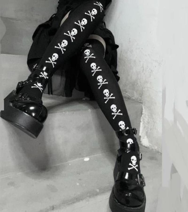 Closer square view of the black skull-line stockings with crossed legs on steps.
