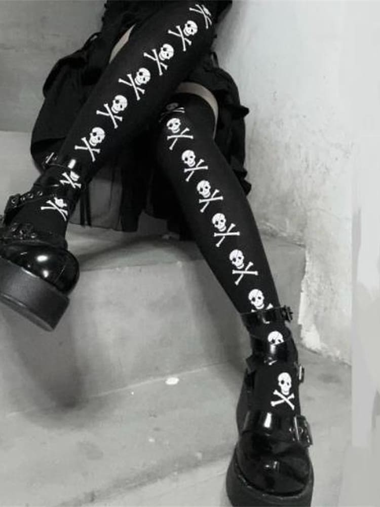 Black stockings with white skull-and-crossbones lines, shown with crossed legs on steps.