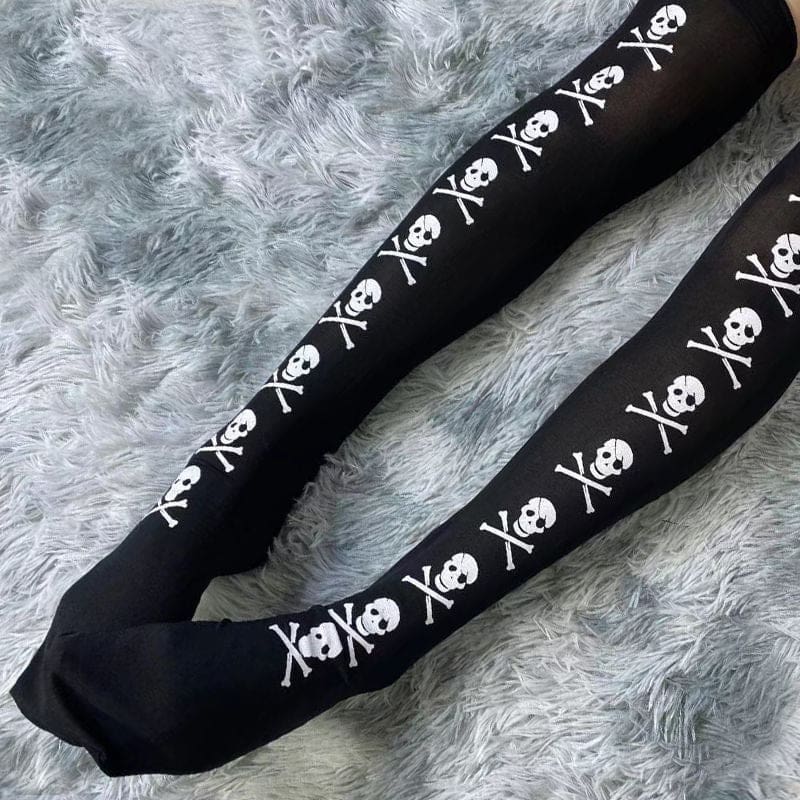 Cropped diagonal view of black stockings with repeating white skulls and crossbones.
