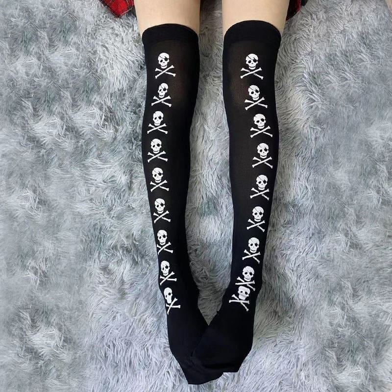 Square view of extended legs in black skull-and-crossbones stockings on a grey rug.