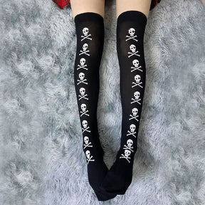 Black stockings with white skull-and-crossbones lines displayed with legs extended over a grey rug.