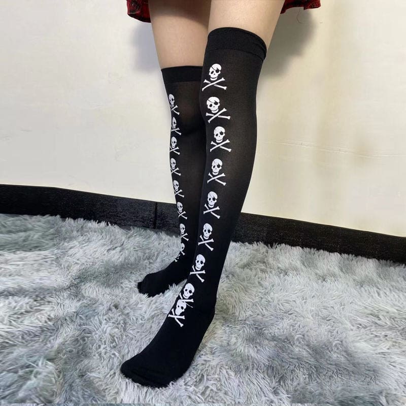 Standing side view of black thigh-high stockings, showing the vertical white skull motif.