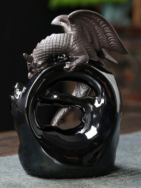Rear view of the gray dragon incense burner, showing raised ridged wings and a scaled body perched over a glossy black open arch.