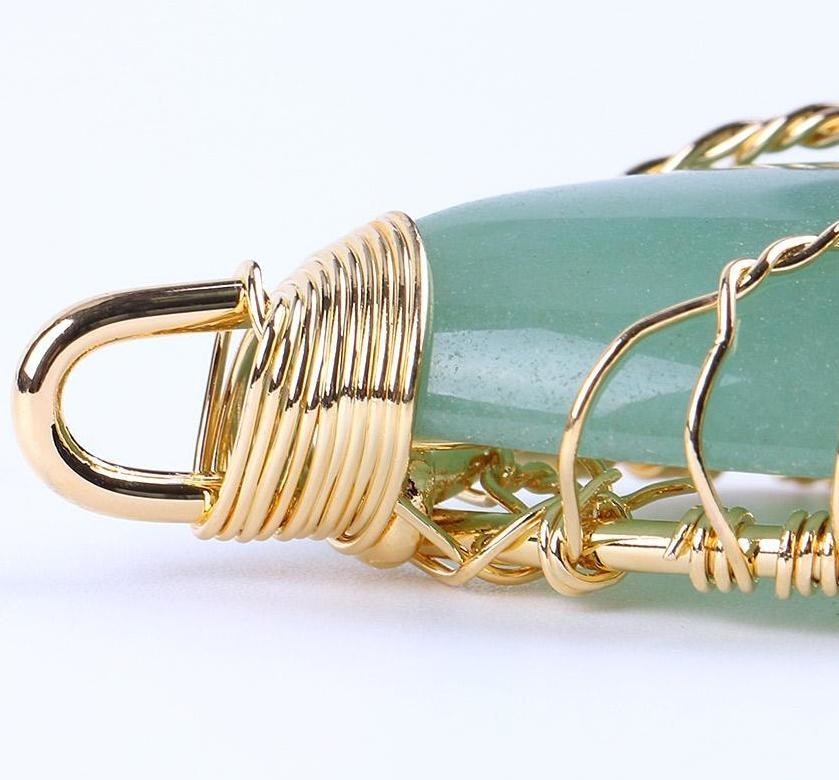 Close-up of the green stone pendant's wrapped bail and fine branching wirework.