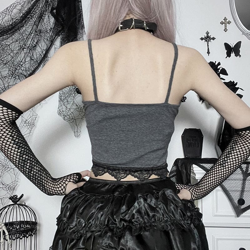 Wider rear view of the grey spaghetti-strap tank with its plain back and scalloped black lace hem. Fishnet arm warmers and dark bottoms complete the styled outfit.