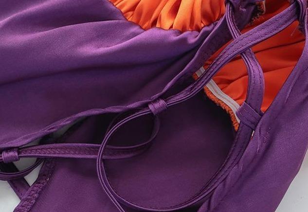 Orange and purple Halloween bodysuit with ruffled trim, a bat neckline accent, halter ties, and lace-up sides