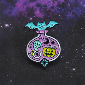 Pastel Halloween potion-bottle pin against a purple galaxy background, with a turquoise bat across the top and a diamond-shaped turquoise accent at the bottom.