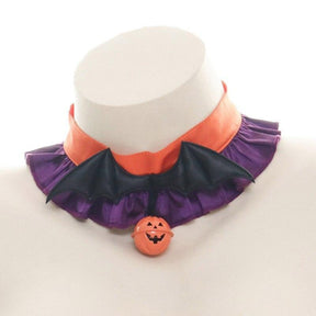 Orange and purple ruffled Halloween choker on a white display bust, with black bat wings and an orange jack-o-lantern charm at the center.