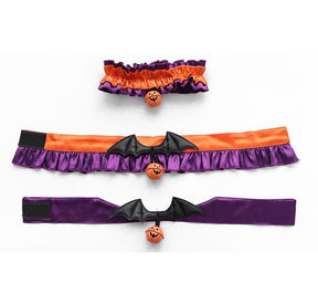 Three pumpkin chokers laid open in rows, showing their different purple and orange bands, ruffled edges and bat-wing decorations.