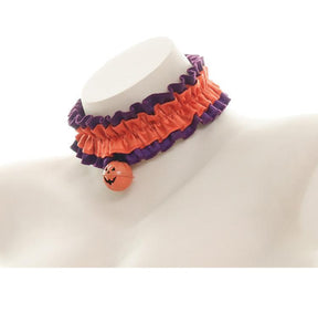 Orange ruffled pumpkin choker viewed from an angle on a white bust, showing the gathered band and narrow purple trim.