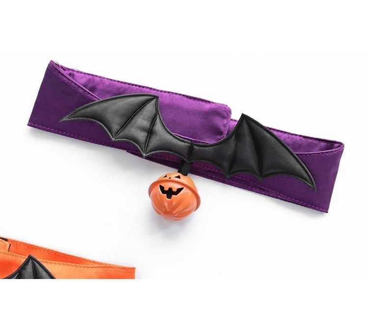 Close-up of the plain purple Halloween choker laid flat, with textured black bat wings and an orange jack-o-lantern charm centered below.