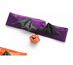 Angled close-up of the purple bat-wing choker on white, with the raised wing shape above the orange pumpkin charm.