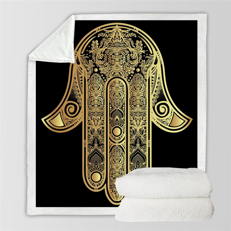 Full black and gold hamsa blanket design beside a folded view of the pale sherpa reverse.