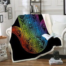 Rainbow hamsa artwork on a black sherpa throw draped over a chair.
