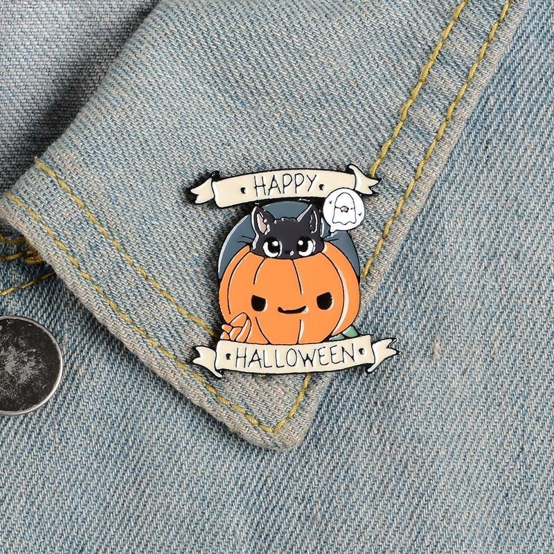 Happy Halloween pumpkin and black cat pin attached to a light denim collar near a dark button and contrast stitching.