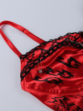 Detail of an adjustable red shoulder strap and black-trimmed cup, showing a small slider above the graphic print.