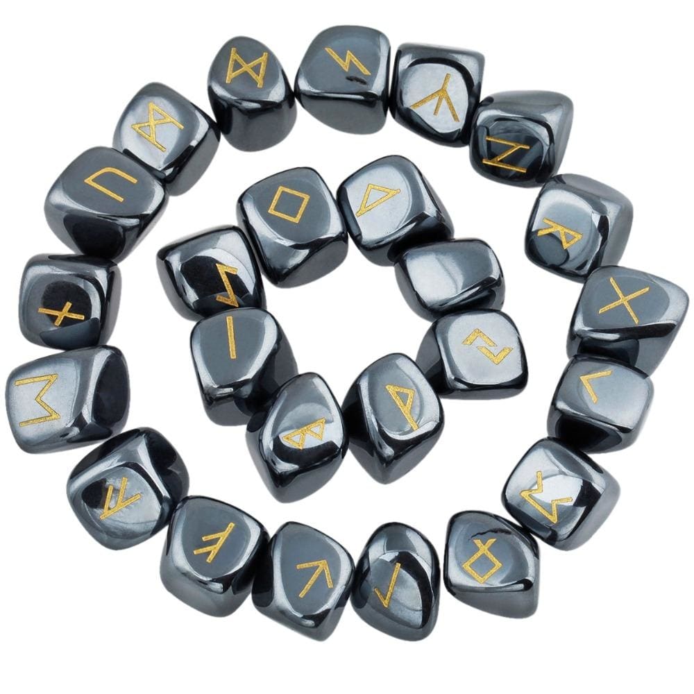 Hematite rune stones arranged in a circle, with dark metallic grey polished surfaces and gold-coloured characters. The set includes a blank stone.
