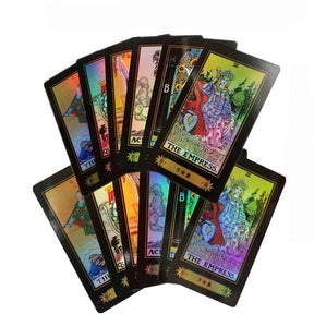 Two fans of holographic tarot cards on white, showing rainbow fronts above a spread of ornate black-and-gold backs.