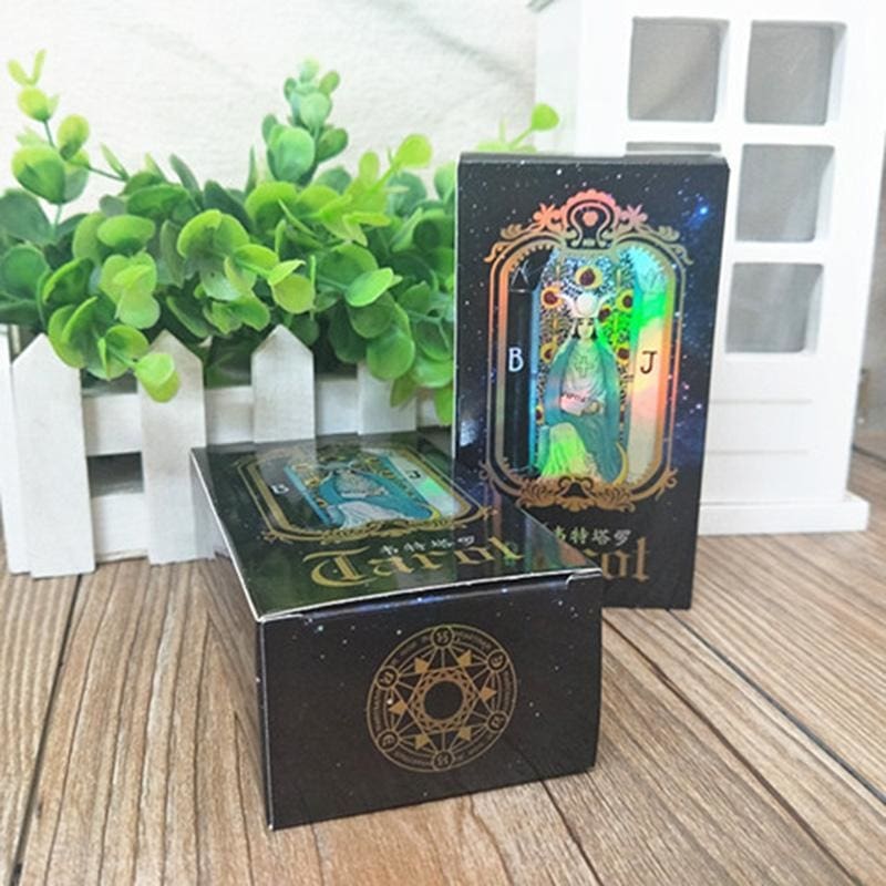 Two black holographic tarot boxes arranged together, with one standing upright to show its reflective front artwork.