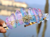 Iridescent crystal point tiara with a gold-tone sun face and a row of rainbow-reflective points across the band.