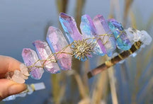 Iridescent crystal tiara with a pointed gold-tone sunburst emblem and rainbow colours across the tall crystal surfaces.