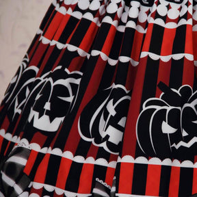 Close view of the Halloween skirt’s red and black stripes, white-outlined pumpkin faces and scalloped printed borders.