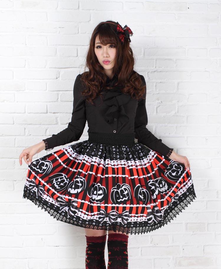 Front outfit view of the pumpkin print skirt spread gently at both sides, showing the wide black waistband and lace border beneath the jack-o-lantern faces.