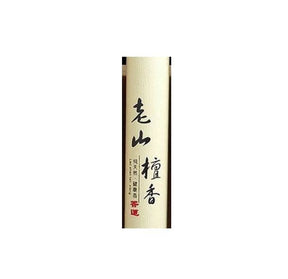 Close view of the pale Laoshan sandalwood incense tube, showing vertical Chinese lettering and a small red seal.