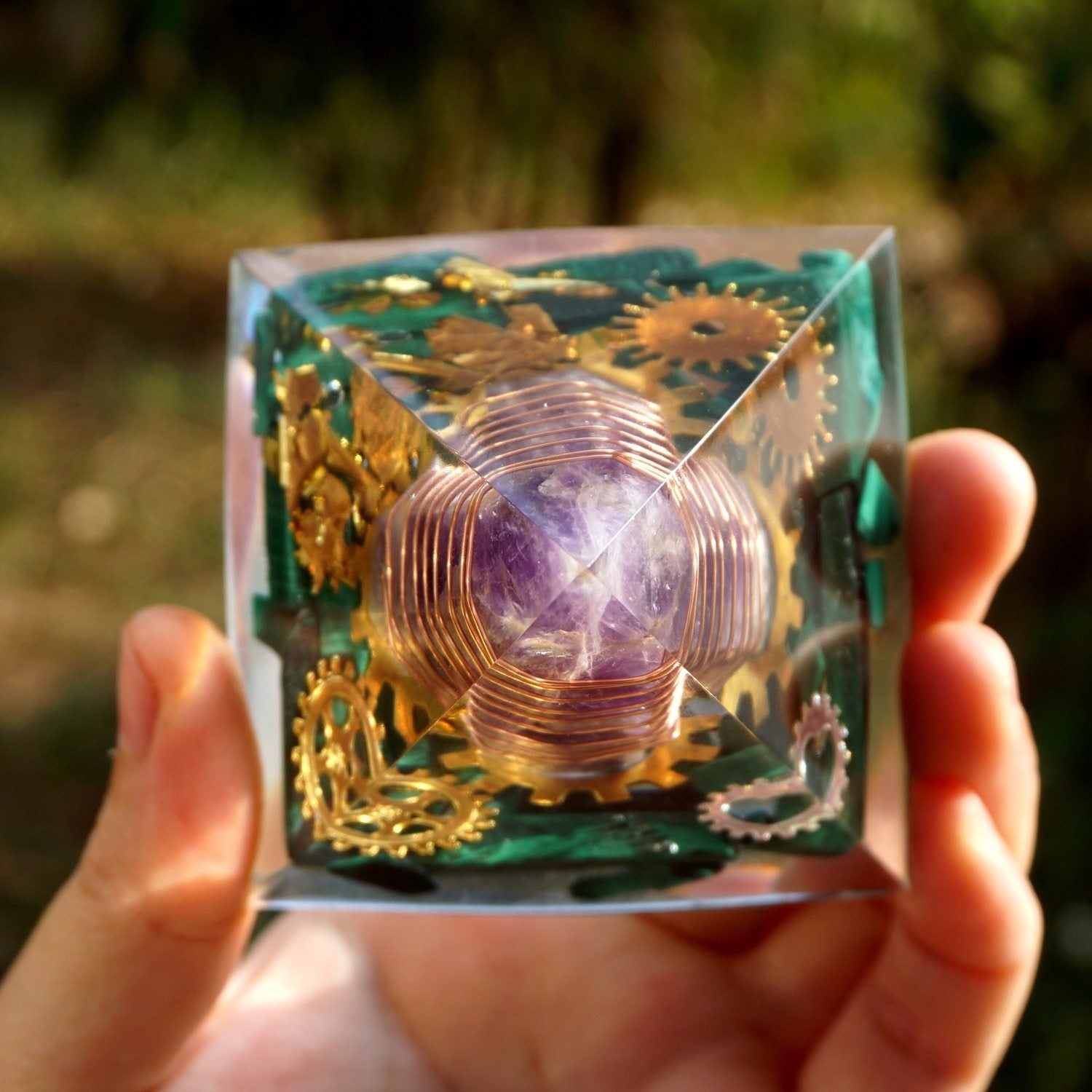 Overhead view through the pointed pyramid, showing green malachite pieces around the wrapped amethyst centre.