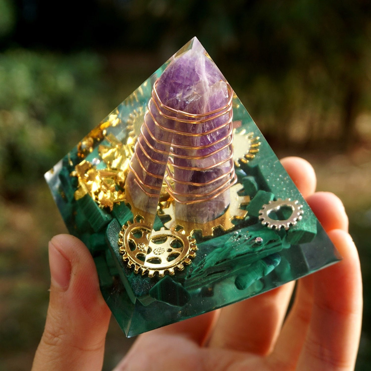 Angled upper view of the clear malachite pyramid, showing the wrapped amethyst point above the green stone base.