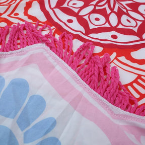 Close view of a printed throw edge with white fringe and folded fabric, showing the hem and reverse of the cloth.