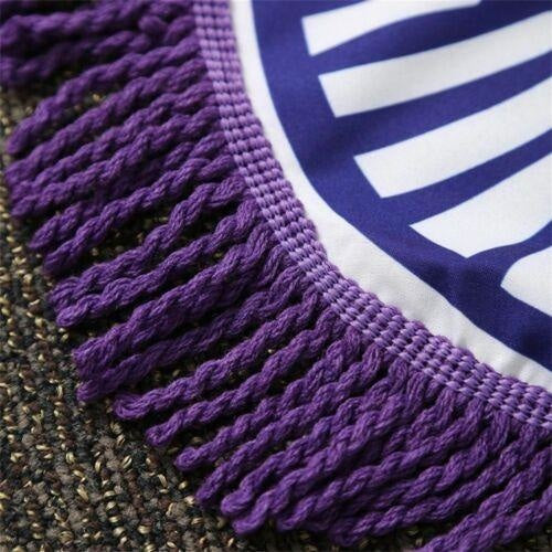 Close-up of the purple patterned edge and white knotted fringe of a mandala flower throw.