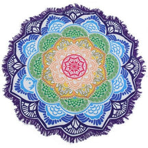 Purple-edged mandala flower throw with green, yellow and blue petal rings around a pink centre, laid flat with white fringe visible.