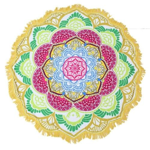 Full view of the yellow-and-green mandala throw, with a pink central flower, blue inner rings and white fringe around the outside.