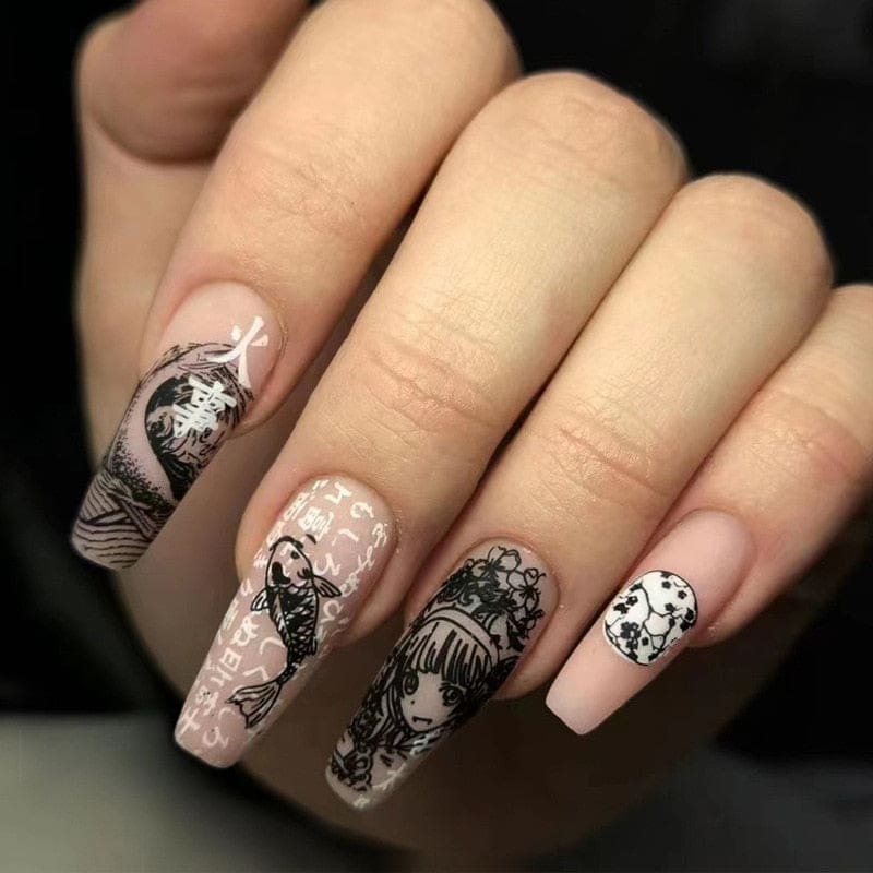 Long squared press-on nails with black-and-white manga-inspired portraits, fish, wave patterns and decorative lettering over pale pink bases.