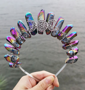 Front view of a metallic rainbow crystal point crown with a silver-tone triple moon emblem and wire-wrapped band.