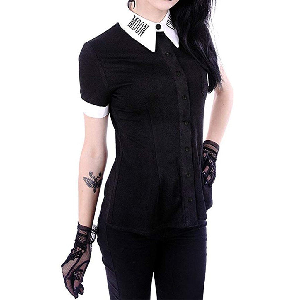 Angled front view of the fitted black Moon Child blouse worn over black trousers, showing the button placket and contrasting white collar and short-sleeve cuffs.
