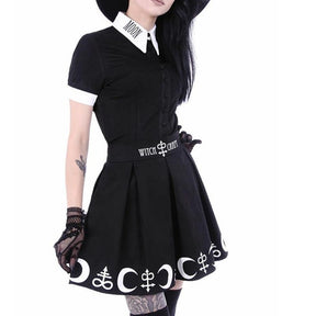 Black Moon Child blouse worn tucked into a separate black symbol-print skirt. The white pointed collar and sleeve cuffs contrast with the short sleeves and black button front.