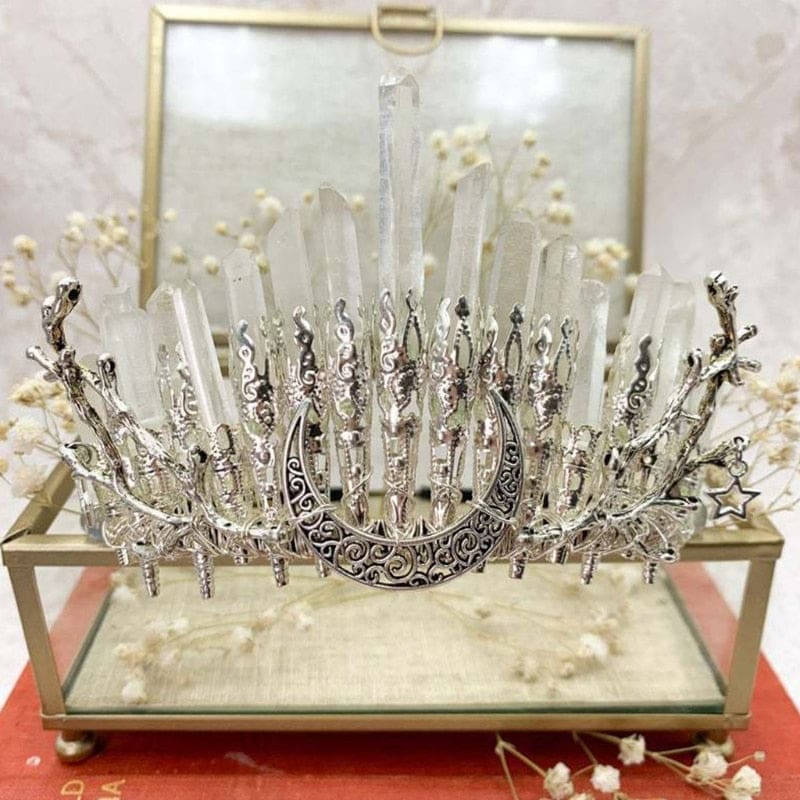 Moonbeam quartz crown displayed on a glass box, with clear points behind an ornate silver-tone moon.